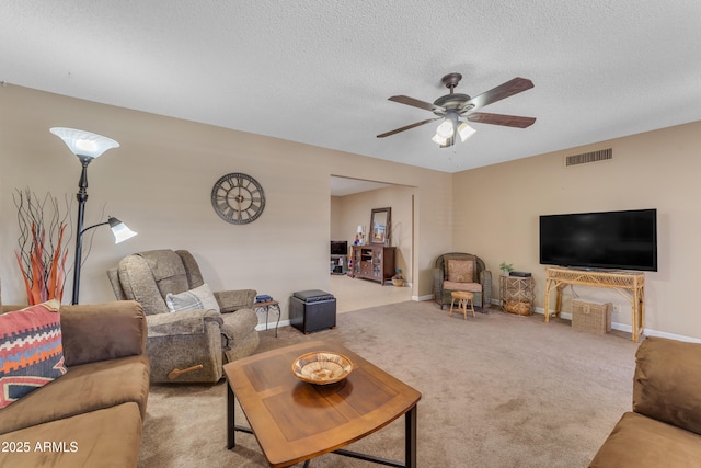 carpeted living area with baseboards, a ceiling fan, visible vents, and a textured ceiling