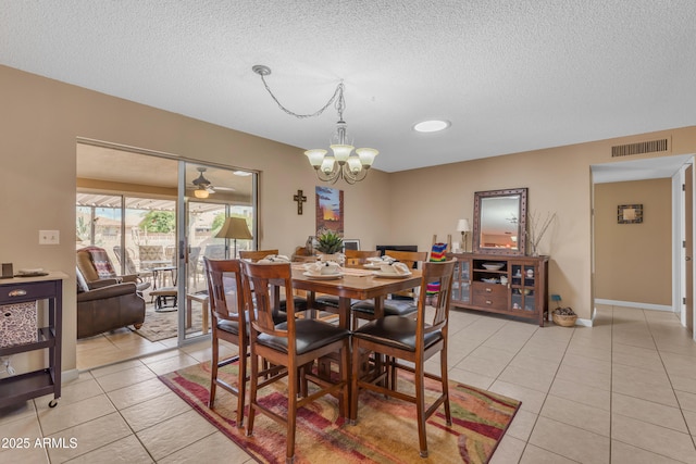 dining space featuring light tile patterned floors, visible vents, and a textured ceiling