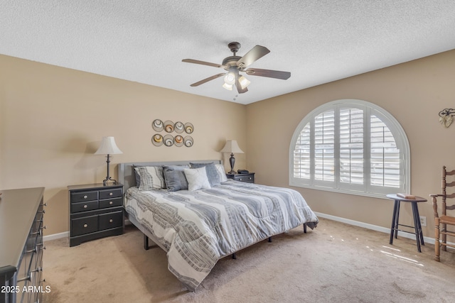 bedroom with baseboards, light colored carpet, a ceiling fan, and a textured ceiling