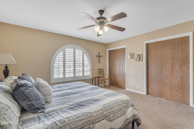 carpeted bedroom featuring a ceiling fan, baseboards, and a textured ceiling