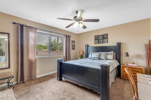 bedroom featuring a ceiling fan, baseboards, carpet floors, and a textured ceiling