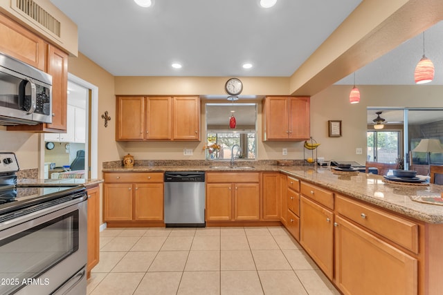 kitchen with a sink, recessed lighting, appliances with stainless steel finishes, light tile patterned flooring, and a peninsula