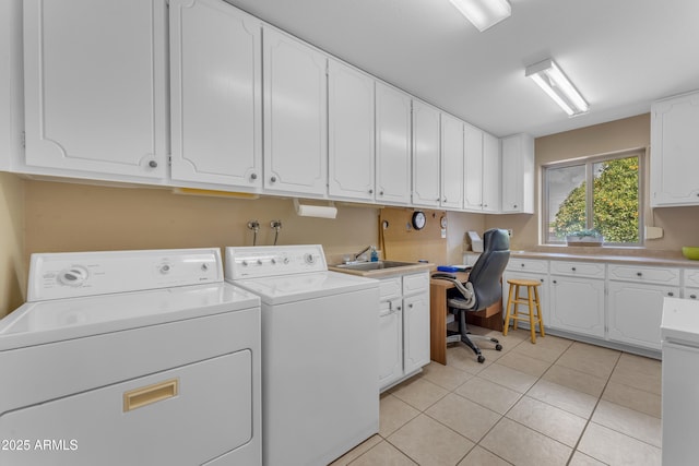 washroom featuring washer and dryer, cabinet space, light tile patterned flooring, and a sink