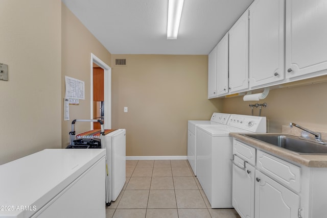 laundry room with visible vents, light tile patterned floors, cabinet space, independent washer and dryer, and a sink