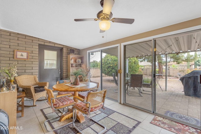 sunroom / solarium with a ceiling fan and vaulted ceiling