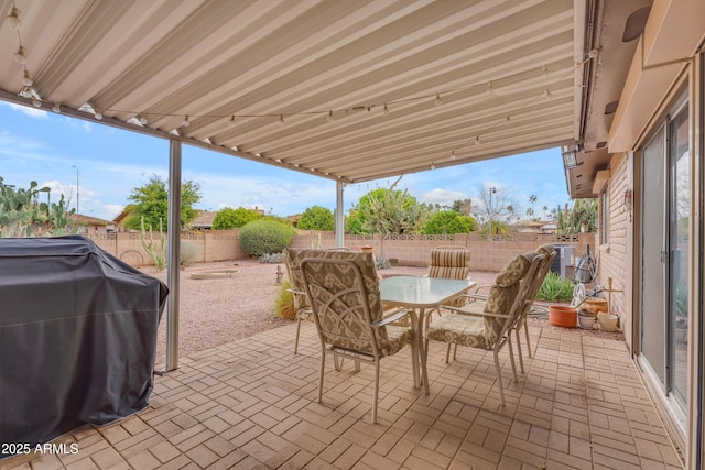 view of patio with outdoor dining area, a fenced backyard, cooling unit, and a grill