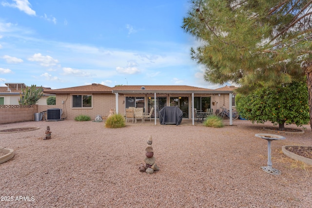 rear view of property featuring brick siding, central air condition unit, a patio, and fence