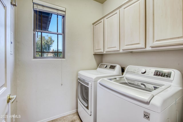 laundry area with light tile patterned flooring, cabinets, and separate washer and dryer