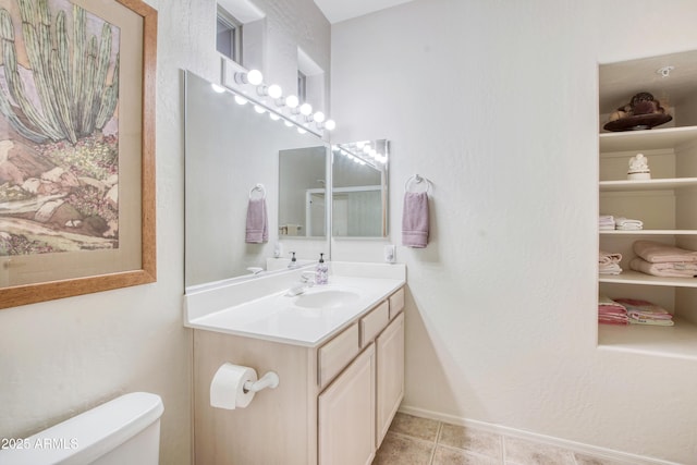 bathroom featuring vanity, tile patterned floors, and toilet