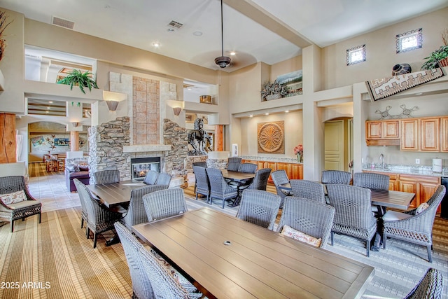 dining space featuring a high ceiling, sink, and a fireplace