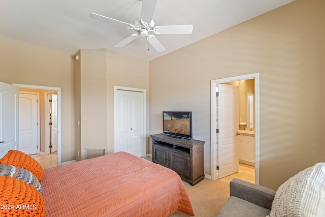 bedroom with a closet, light colored carpet, ensuite bath, and ceiling fan