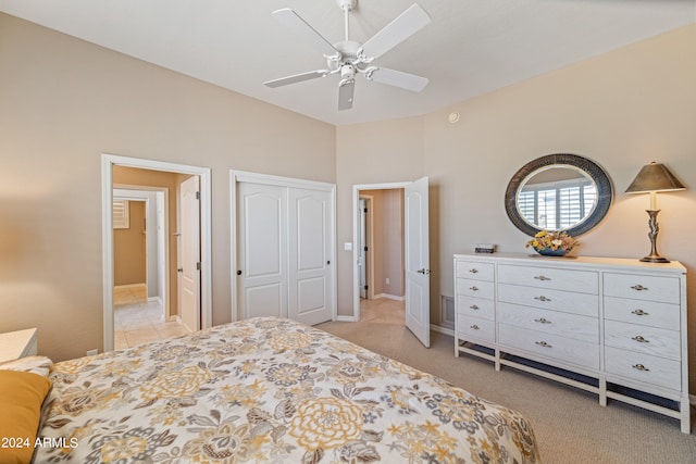 bedroom with ceiling fan, light colored carpet, and a closet