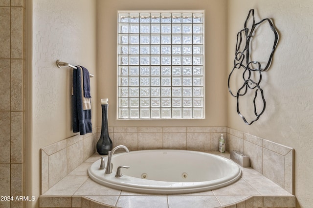 bathroom featuring a relaxing tiled tub and a wealth of natural light