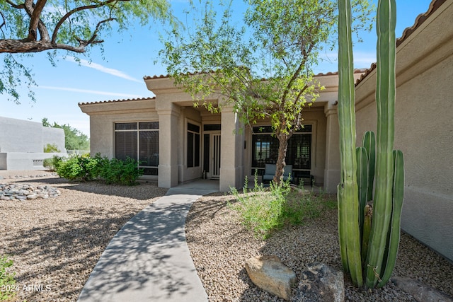 view of exterior entry with a patio