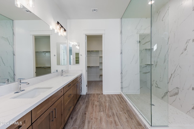 bathroom featuring hardwood / wood-style floors, vanity, and tiled shower