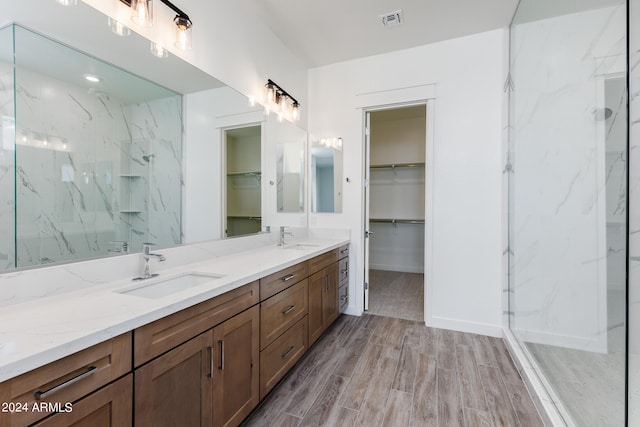 bathroom with a tile shower, hardwood / wood-style floors, and vanity