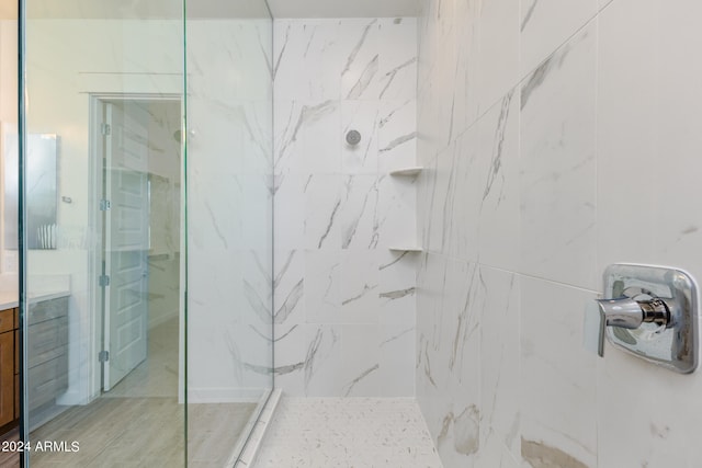 bathroom featuring tiled shower and vanity