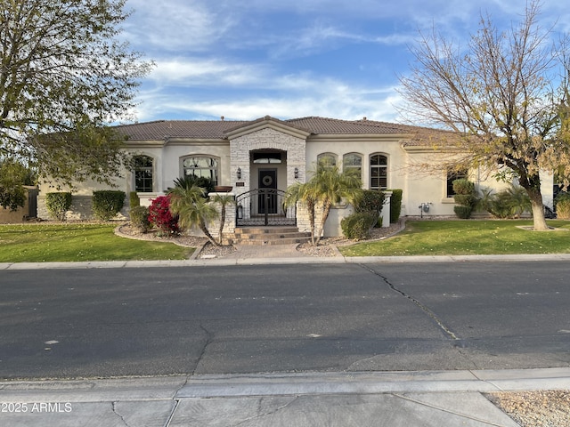 mediterranean / spanish house featuring a front lawn