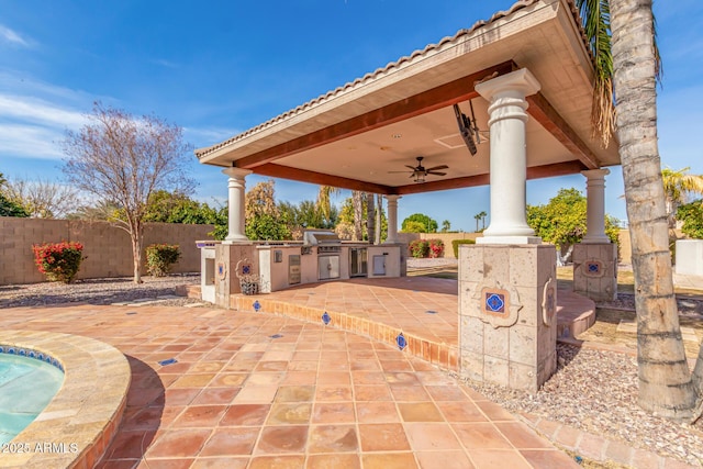 view of patio featuring a grill, a gazebo, ceiling fan, and exterior kitchen