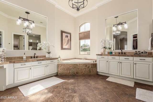 bathroom featuring ornamental molding, tiled bath, a chandelier, and vanity