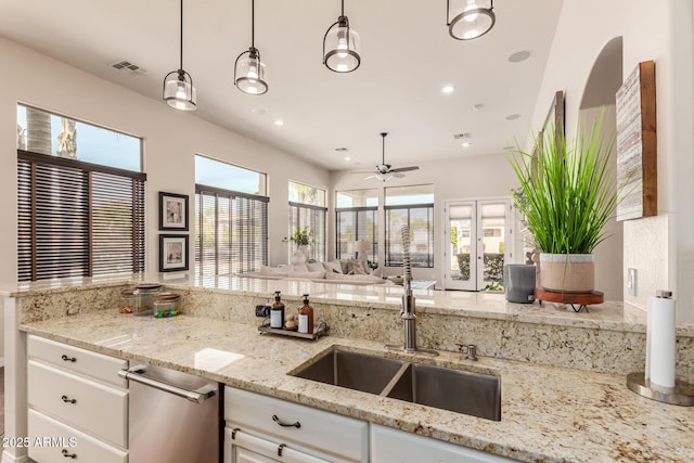 kitchen with pendant lighting, light stone counters, and white cabinets