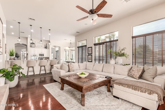 living room with ceiling fan and dark hardwood / wood-style flooring