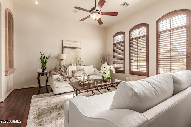 living room with dark wood-type flooring and ceiling fan