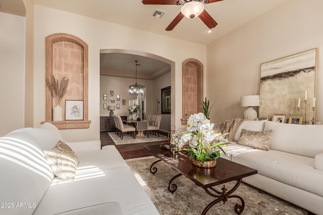 living room with hardwood / wood-style flooring and ceiling fan with notable chandelier