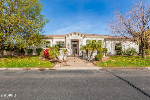 mediterranean / spanish home with a front yard