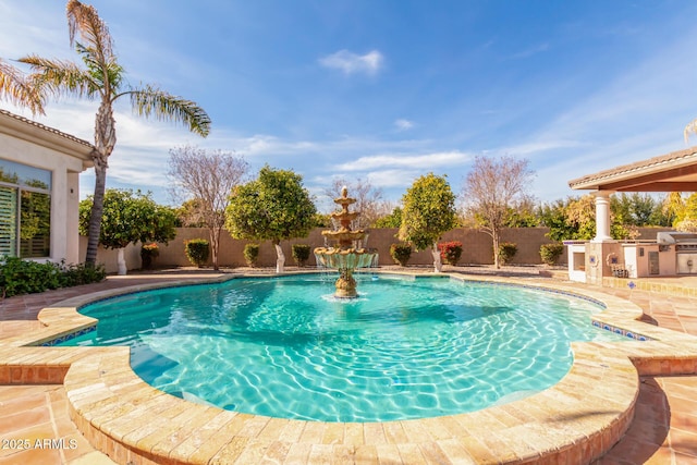 view of swimming pool with grilling area, a patio, and an outdoor kitchen