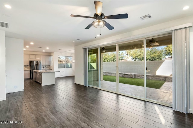 unfurnished living room with sink and ceiling fan