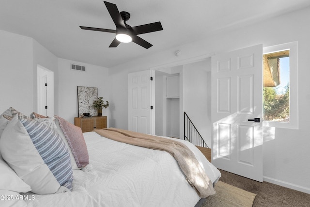 carpeted bedroom featuring ceiling fan and a closet