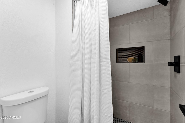 bathroom featuring a shower with curtain and toilet