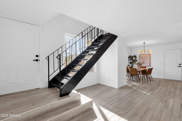 stairway with a notable chandelier and wood-type flooring