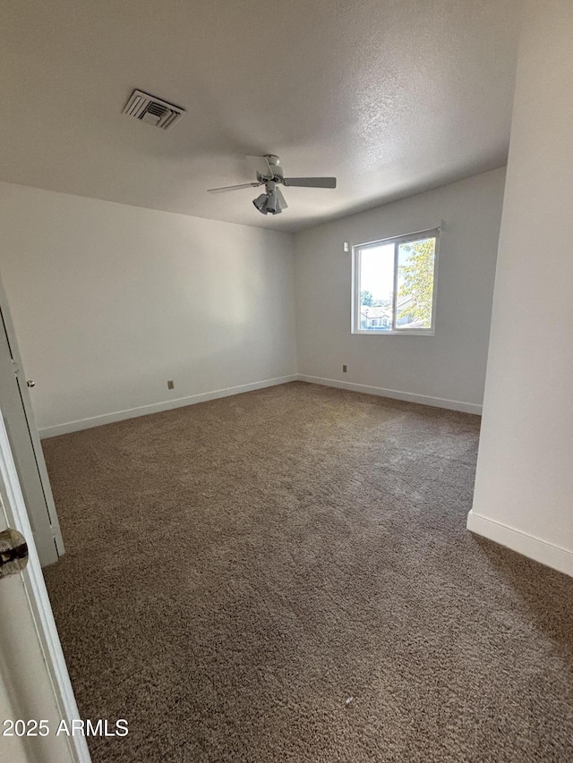 carpeted spare room with a textured ceiling and ceiling fan