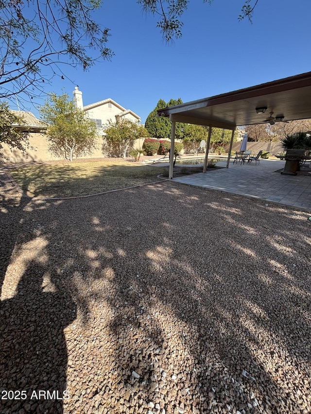 view of yard featuring ceiling fan and a patio area