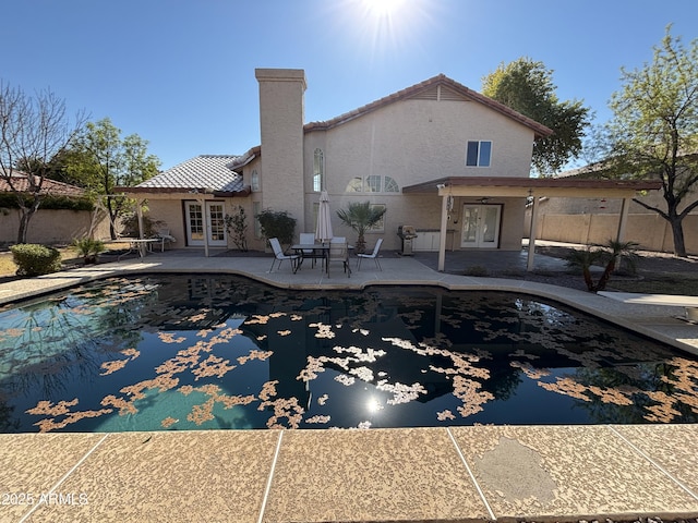 view of swimming pool with french doors and a patio area