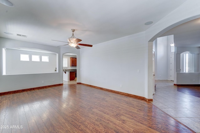 interior space featuring visible vents, baseboards, ceiling fan, and hardwood / wood-style floors