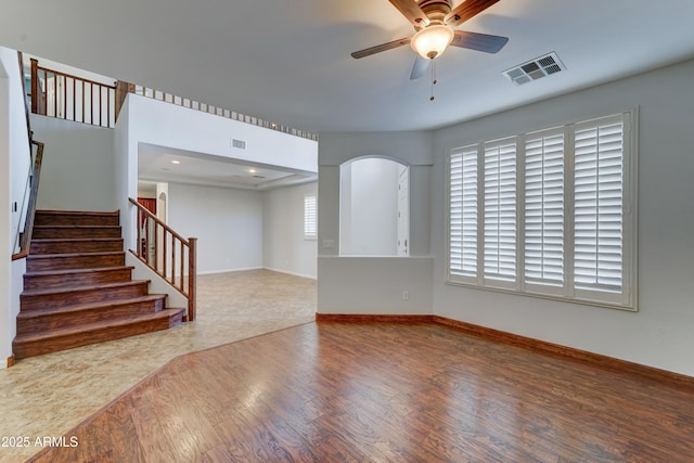 interior space featuring stairway, a ceiling fan, wood finished floors, visible vents, and baseboards