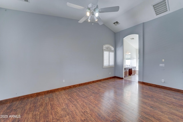 empty room featuring vaulted ceiling, visible vents, ceiling fan, and wood finished floors