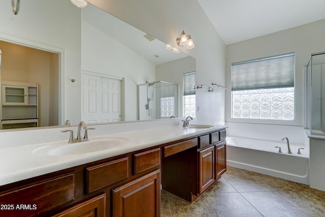 bathroom with vaulted ceiling, a stall shower, and a sink