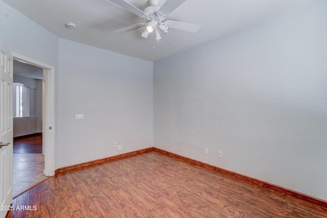 empty room with wood finished floors, baseboards, and ceiling fan