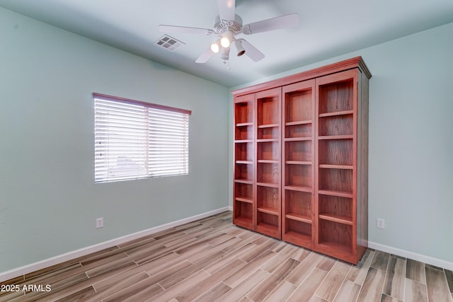 unfurnished bedroom featuring a ceiling fan, wood finished floors, visible vents, and baseboards