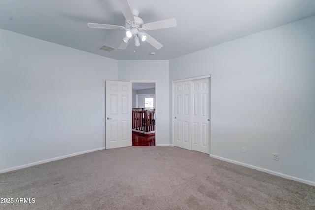 unfurnished bedroom featuring visible vents, a closet, carpet, baseboards, and ceiling fan