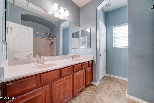 full bathroom featuring a sink, visible vents, baseboards, and double vanity