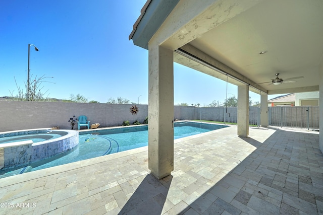 view of pool featuring a pool with connected hot tub, a patio, a ceiling fan, and a fenced backyard