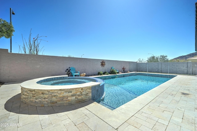 view of swimming pool featuring a pool with connected hot tub, a fenced backyard, and a patio area