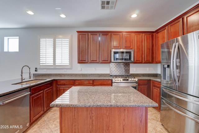 kitchen featuring visible vents, light stone counters, light tile patterned floors, appliances with stainless steel finishes, and a sink