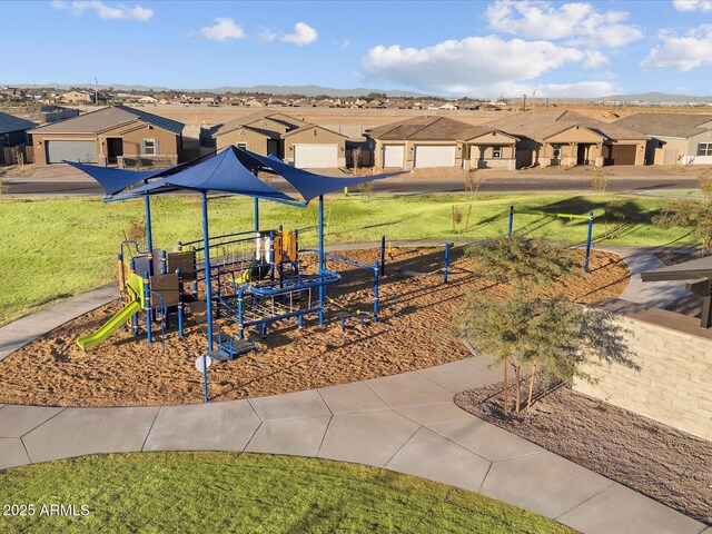 communal playground featuring a residential view and a lawn