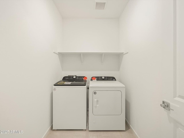 washroom featuring laundry area, baseboards, visible vents, and washer and clothes dryer